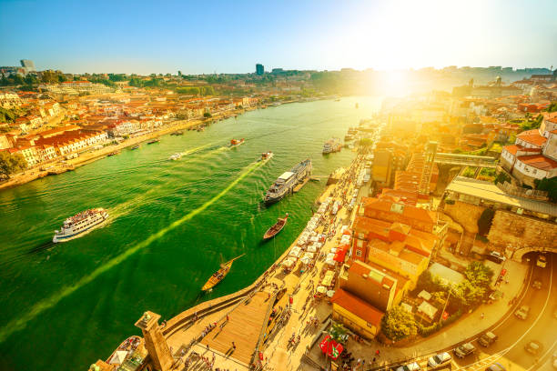 Douro River skyline at sunset Aerial view of Oporto skyline and Ribeira Waterfront from Dom Luis I Bridge at twilight. Picturesque urban cityscape of Porto in Portugal. Tourist boats cruising on Douro River at sunset light. rabelo boat stock pictures, royalty-free photos & images