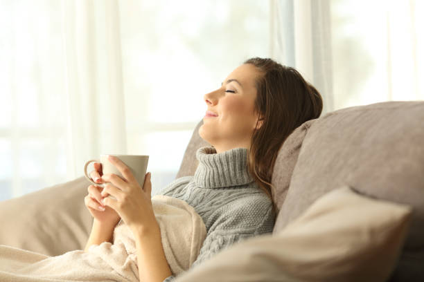 mujer relajante en casa sosteniendo una taza de café - gente tranquila fotografías e imágenes de stock