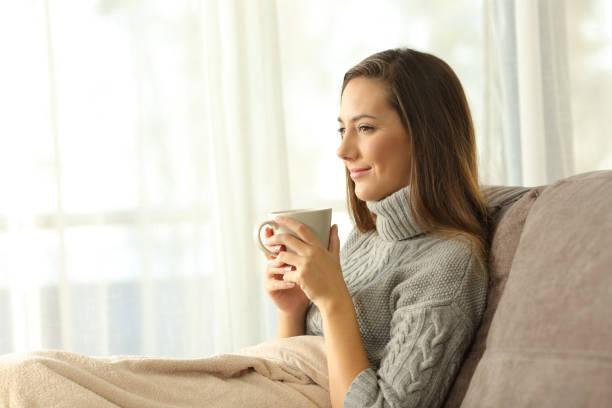 istock Pensive relaxed woman holding coffee at home 877068552