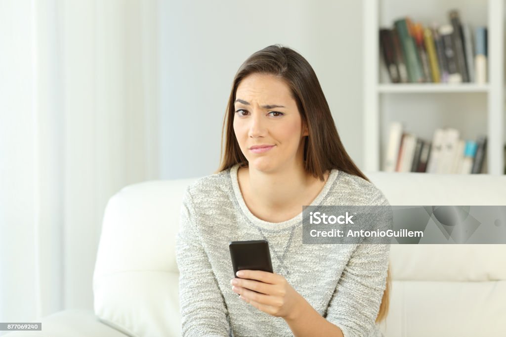 Verdächtige Frau mit Telefon betrachten Sie - Lizenzfrei Frauen Stock-Foto