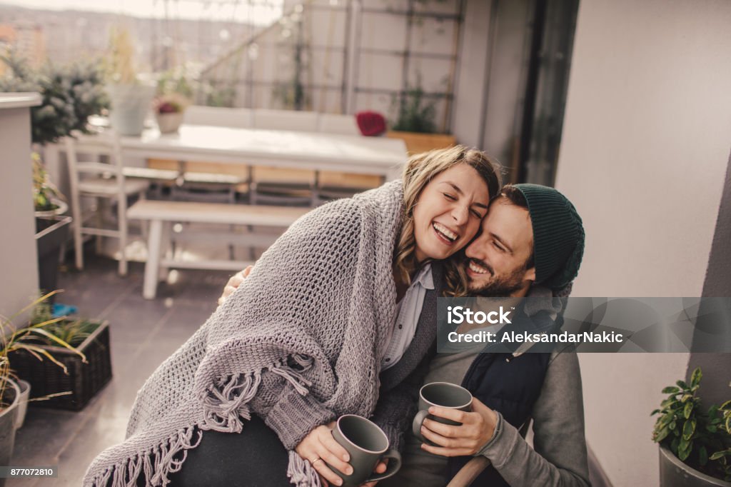 Romantic date on our rooftop garden Photo of a young couple taking a few minutes off to relax and drink coffee on their balcony, on a beautiful autumn day Winter Stock Photo