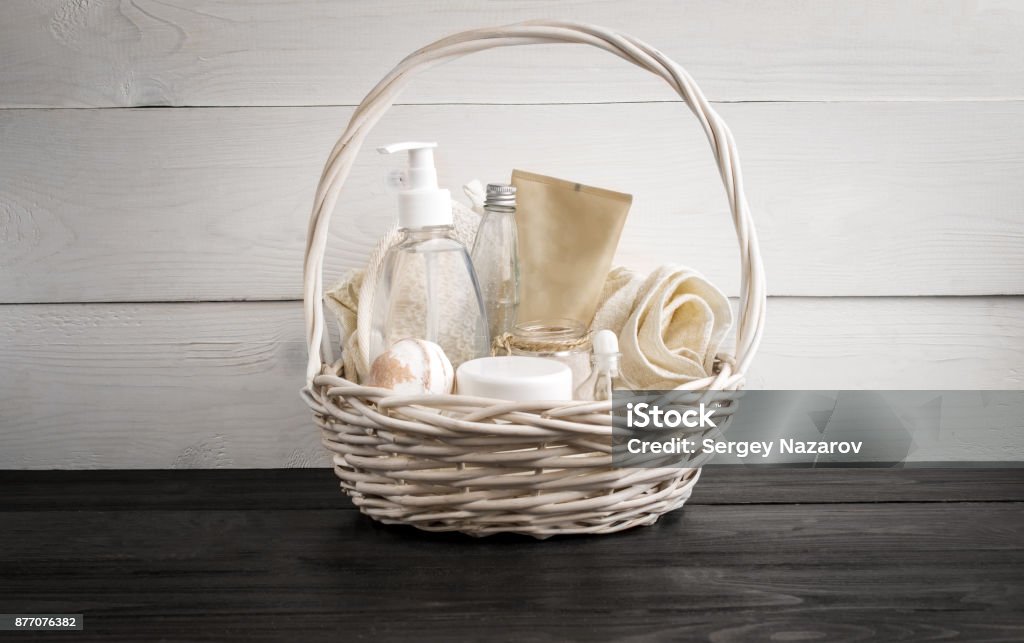Wicker basket with spa treatments on table Wicker basket with spa treatments on wooden table. Still life Basket Stock Photo