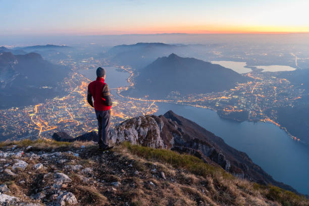 туристы на вершине горы над городом - lake como water italy sunset стоковые фото и изображения