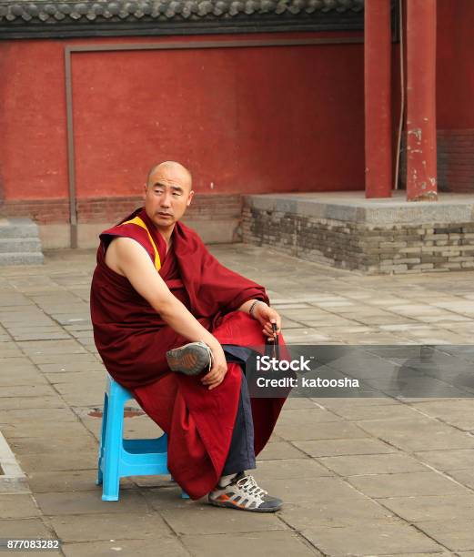 Buddhist Monk With Rosary Sitting In The Yard Of Dazhao Monastery Stock Photo - Download Image Now