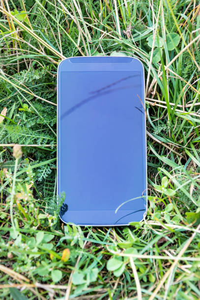 istock Black smartphone lays on the grass. 877084134