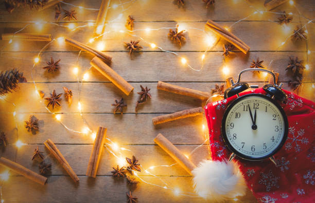 istock alarm clock and cinnamon, star anise with Christmas lights 877086854