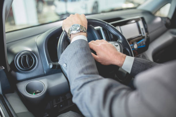 istock Mans hands on steering wheel of new electro car 877091530