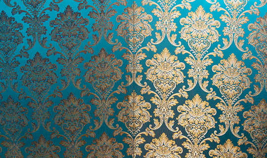 The texture of silk with a floral pattern. Chinese silk brocade, beautiful expensive fabric background. Gold ornament turquoise embroidery fabric