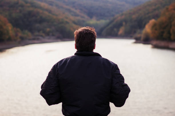 istock A man standing by the lake 877095230