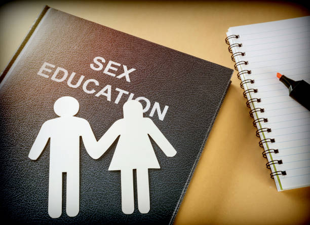 Book of sexual education next to a notebook, conceptual image stock photo