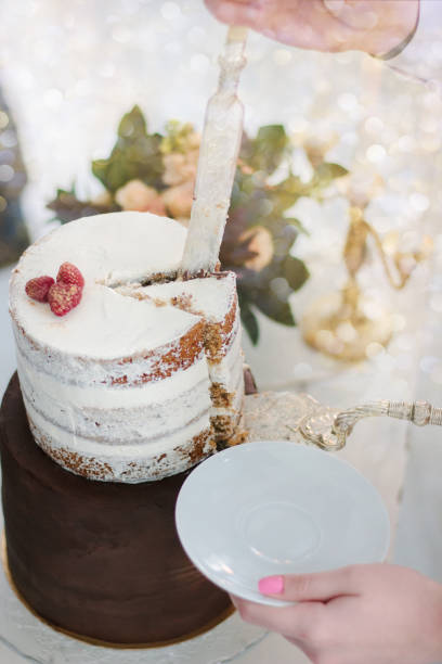 istock Hand with knife cutting christmas cake during celebration. 877101546