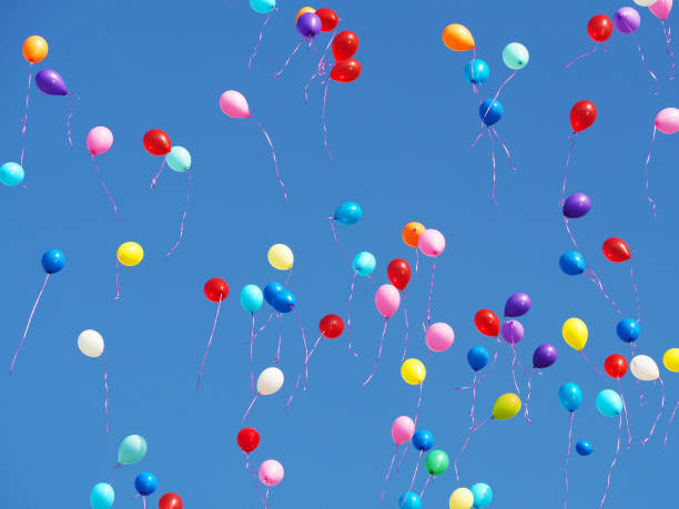 istock Multicolored balloons filled with helium in the blue cloudless sky. Flying multicolor balls 877106414