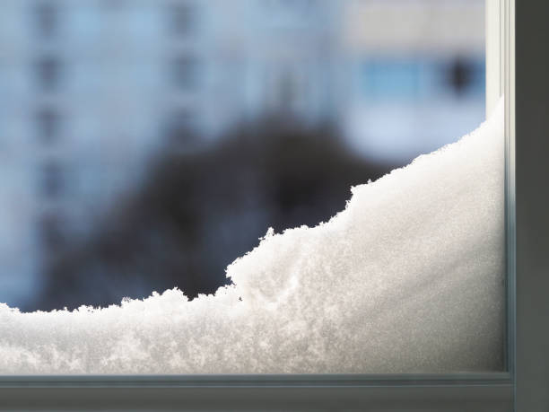 Modern residential window with snow landscape. Snowdrift on the window. Abstract winter backdrop.