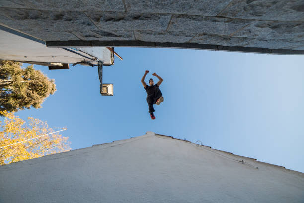Man jumping from one roof to another