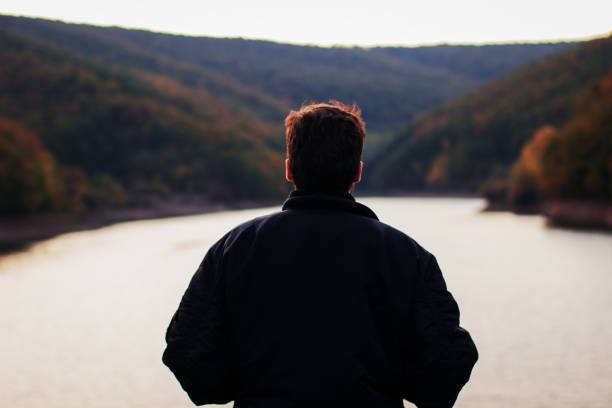 istock A man standing by the lake 877109964
