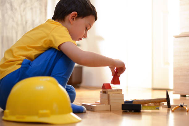 istock Beautiful boy is playing with toy blocks and hand tools 877111206
