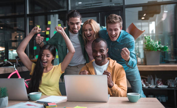 istock Colleagues are looking at screen of laptop while celebrating triumph 877111588
