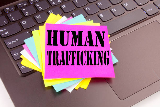 istock Writing Human Trafficking text made in the office close-up on laptop computer keyboard. Business concept for Slavery Crime Prevention Workshop on the black background with copy space 877114362