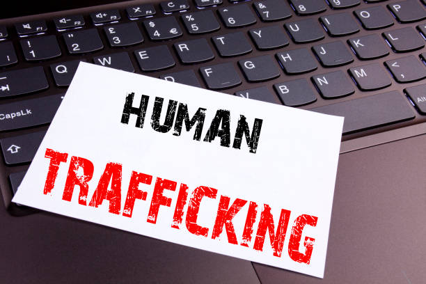 istock Writing Human Trafficking text made in the office close-up on laptop computer keyboard. Business concept for Slavery Crime Prevention Workshop on the black background with copy space 877114452