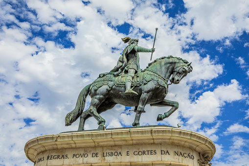 Lisbon, Portugal - August 26, 2017: Equestrian statue of King John I in popular Praca da Figueira in the blue sky with clouds. Lisbon, Portugal, Europe.