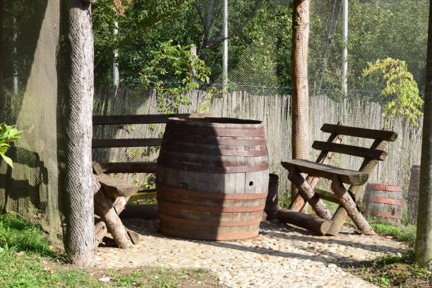 istock Retro styled gazebo with a wooden benches and barrel as a table 877118064