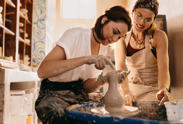 istock Two women at a pottery workshop making clay pots 877118480