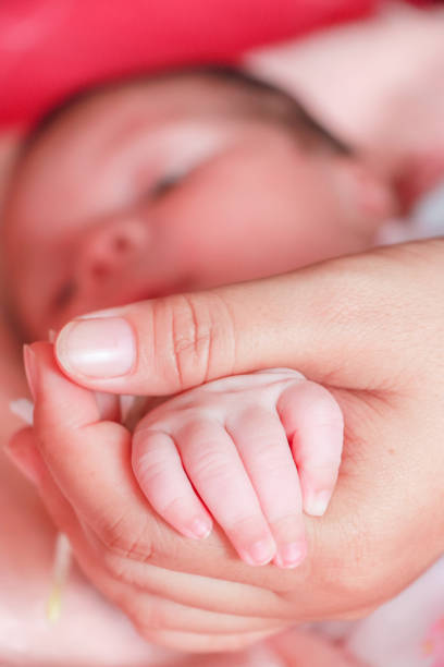 istock baby hand in mom's hand 877118642