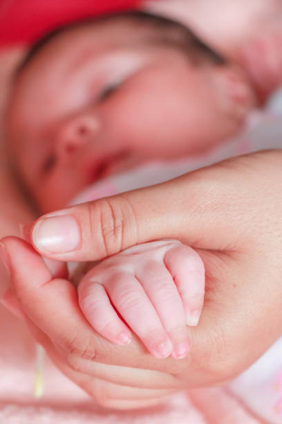istock baby hand in mom's hand 877118654
