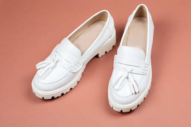 closeup de sapatos mocassim feminino branco sobre um fundo marrom quente - chunky heels - fotografias e filmes do acervo