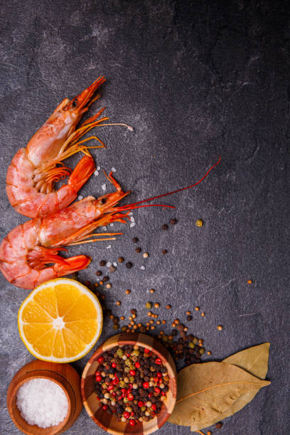 istock Background with prawns, lemon, peppers, salt and a few laurel leaves. 877122902