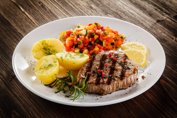 grilled steak, boiled potatoes and vegetable salad - schnitzel cutlet food meal imagens e fotografias de stock