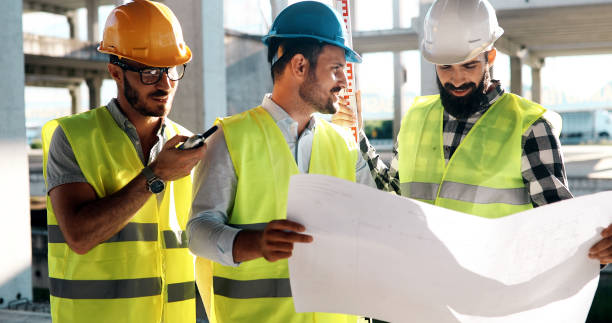 istock Team of construction engineers working on building site 877129512