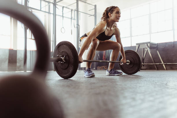 donna che solleva un bilanciere in palestra - powerlifting foto e immagini stock