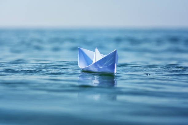 istock Paper boat on sea wave 877133060