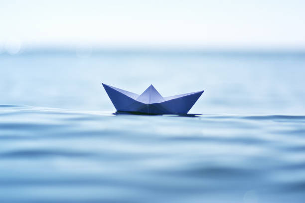 istock Paper boat on sea wave 877133306