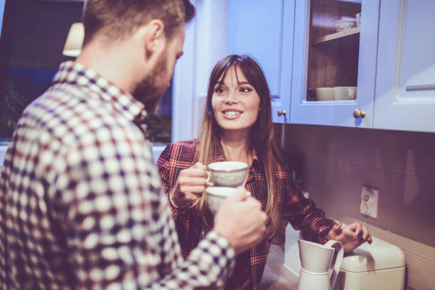 istock Young Smiling Couple Making Coffee in the Kitchen at Home 877140804