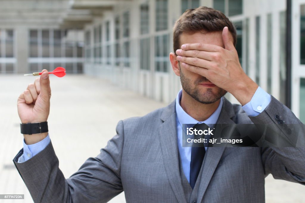 Blind businessman holding a dart Blind businessman holding a dart. Ignorance Stock Photo