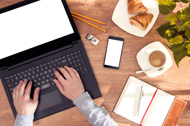 istock Man sits at the desk with laptop and smartphone with empty spaces for your text 877147966