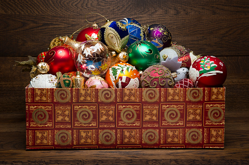 New year toys in box on wooden background, heap of Christmas decorations, xmas winter holidays and celebrations concept