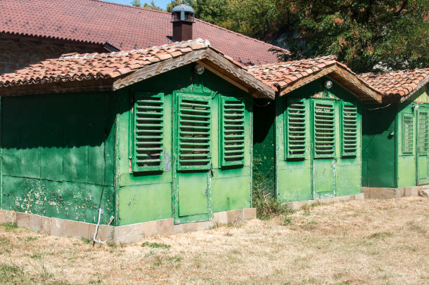 Old vintage obsolete abandoned green wooden camping bungalows in sunny summertime