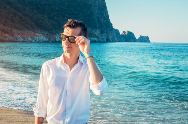 istock Young businessman walks on the beach 877167632
