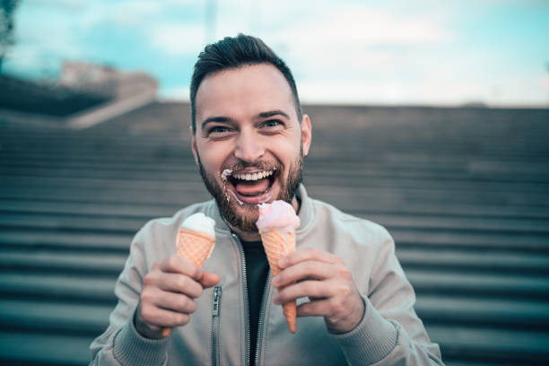 istock Handsome Young Boy Eating Ice Cream From Two Cones 877169252