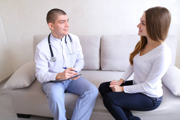 girl came to see male doctor who prescribes treatment. guy and w - cheerful doctor prescribes professional occupation imagens e fotografias de stock