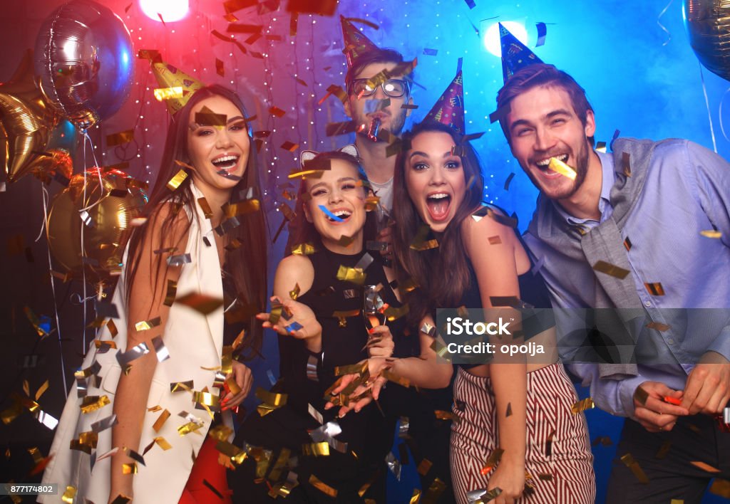 Giovani allegri inondati di coriandoli in una festa del club. - Foto stock royalty-free di Party