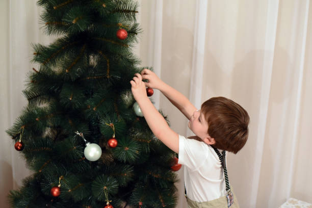 istock Little boy decorates a Christmas tree for New Year 877177530