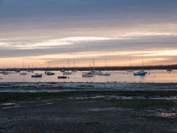 istock sun set sky dramatic clouds sea front beach harbor marina boats moored landscape 877184086
