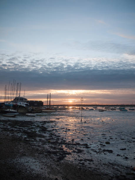 istock sun set sky dramatic clouds sea front beach harbor marina boats moored landscape 877184092