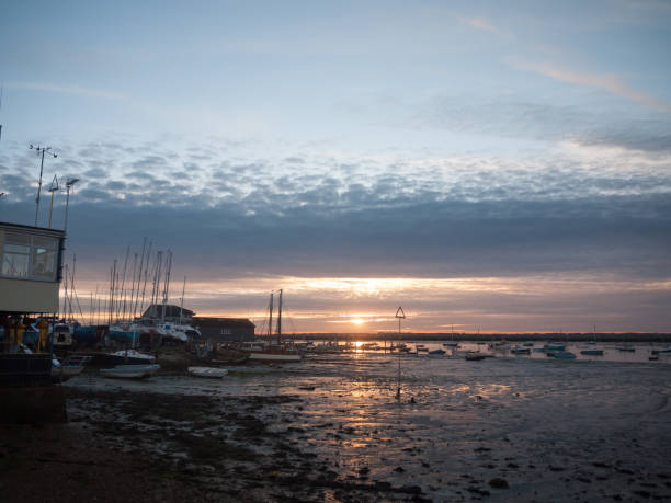 istock sun set sky dramatic clouds sea front beach harbor marina boats moored landscape 877184094
