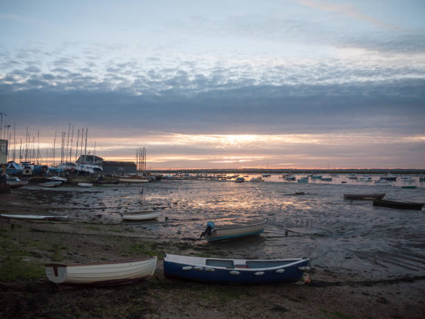istock sun set sky dramatic clouds sea front beach harbor marina boats moored landscape 877184114