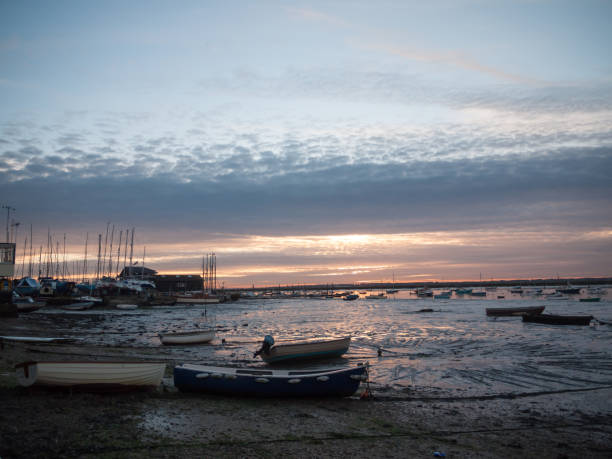 istock sun set sky dramatic clouds sea front beach harbor marina boats moored landscape 877184174